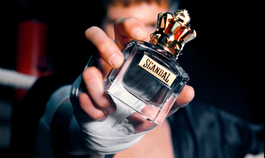 Man wearing a boxing fist wrap and holding a bottle of Jean Paul Gaultier Scandal Eau de Toilette